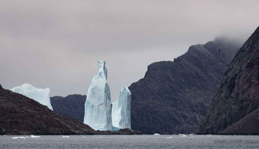 A towering iceberg in Scoresby Sund in a narrow fjord in East Greenland