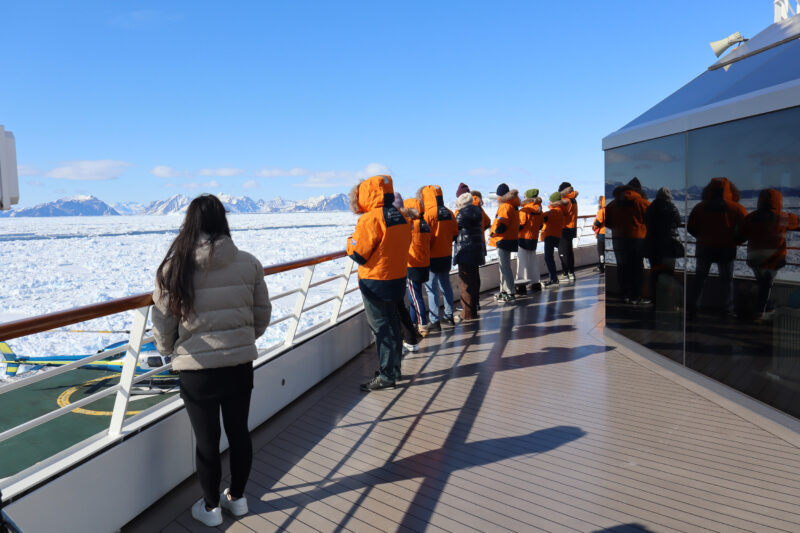 Observation deck 9 on Le Commandant Charcot with guests watching the ice navigation